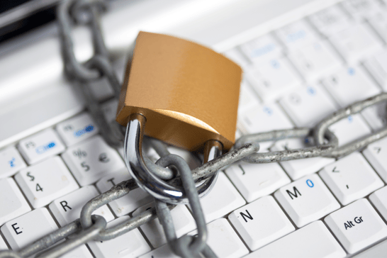 Alt text: A lock and chain on a computer keyboard.